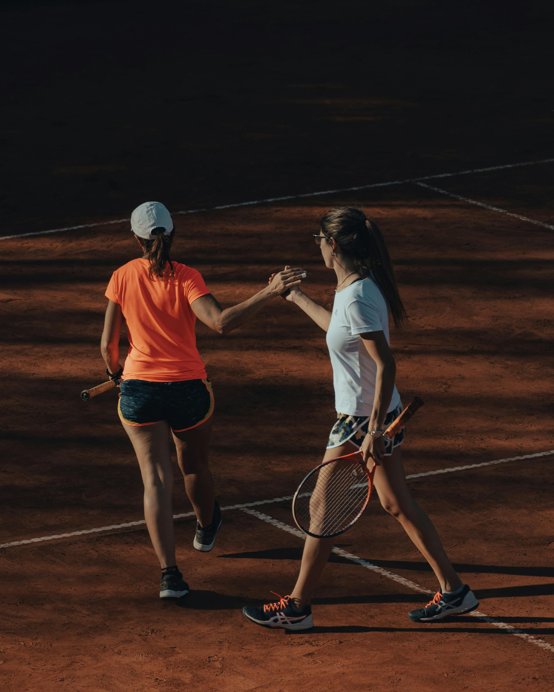 Two tennis players greeting each other on court